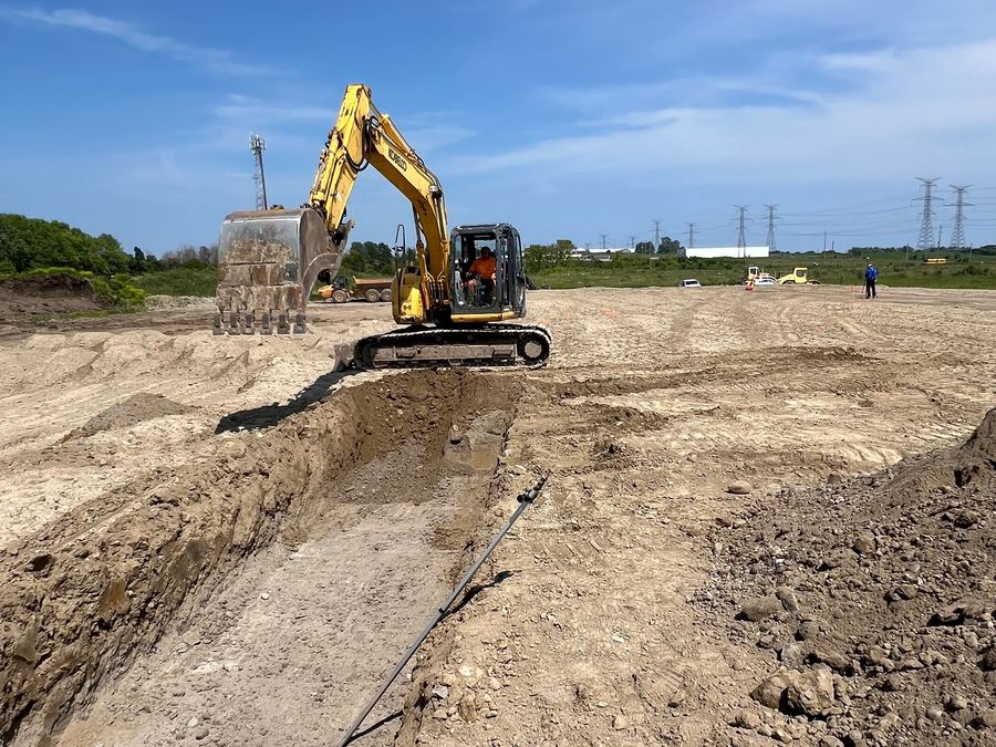 Excavator digging foundation trenches at the Bowmanville warehouse site